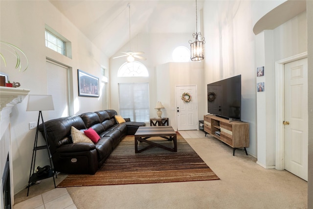 living room featuring light tile patterned floors, ceiling fan with notable chandelier, and high vaulted ceiling