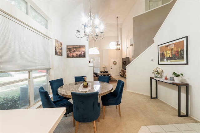 dining room with a high ceiling, light carpet, and a notable chandelier