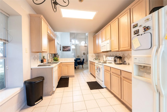 kitchen featuring tasteful backsplash, white appliances, light brown cabinetry, and light tile patterned floors