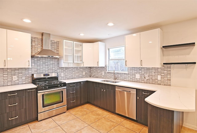 kitchen with dark brown cabinetry, white cabinets, wall chimney exhaust hood, and appliances with stainless steel finishes