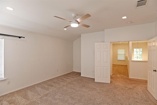 carpeted empty room with visible vents, a ceiling fan, recessed lighting, baseboards, and vaulted ceiling