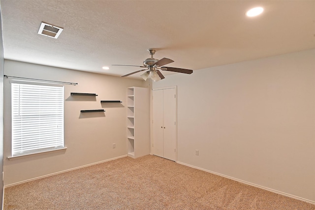 spare room with visible vents, recessed lighting, ceiling fan, a textured ceiling, and light carpet