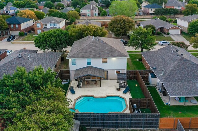 pool at dusk with an in ground hot tub and a patio