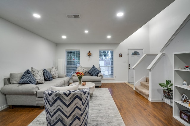 living room with recessed lighting, visible vents, dark wood finished floors, and stairs