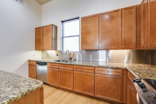 kitchen featuring stainless steel appliances, sink, and light wood-type flooring