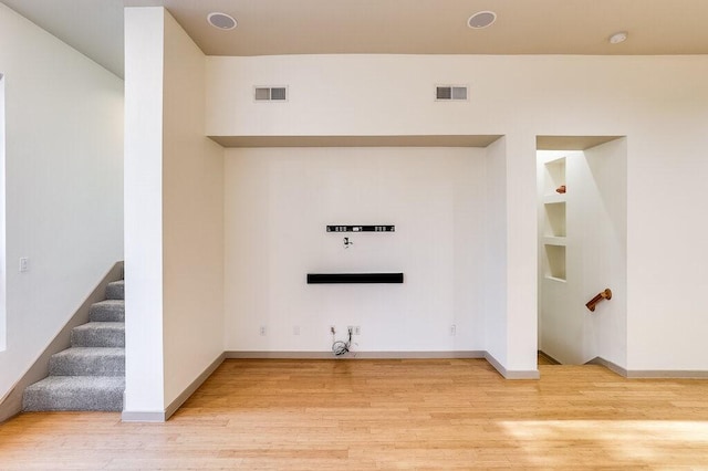 laundry area featuring built in shelves and hardwood / wood-style flooring