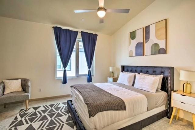 carpeted bedroom with ceiling fan and lofted ceiling