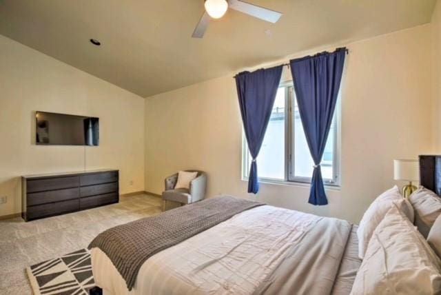 bedroom featuring lofted ceiling, light colored carpet, and ceiling fan