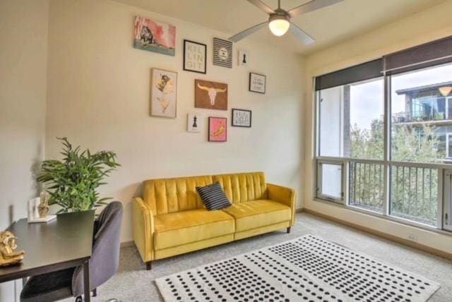 sitting room with ceiling fan and light colored carpet