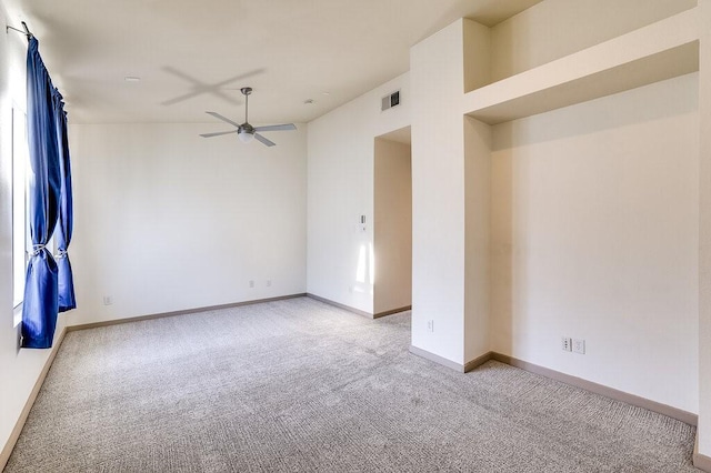 empty room with ceiling fan and light carpet