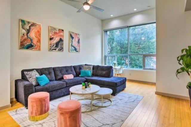 living room with ceiling fan and light wood-type flooring