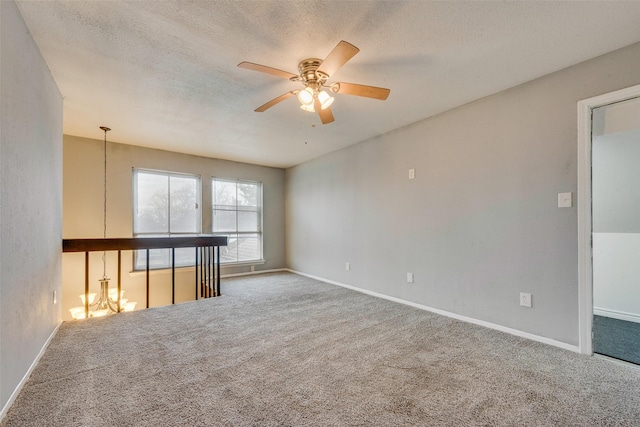 carpeted empty room with ceiling fan and a textured ceiling