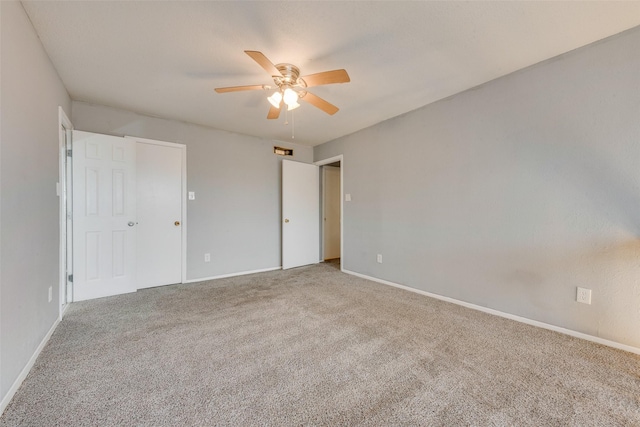 carpeted spare room featuring ceiling fan