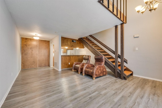 sitting room featuring an inviting chandelier, a textured ceiling, and light hardwood / wood-style flooring