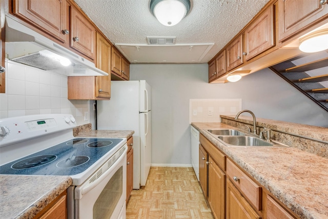 kitchen with white appliances, backsplash, sink, a textured ceiling, and light parquet flooring