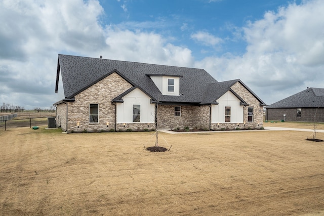 view of front of property with central AC and a front yard