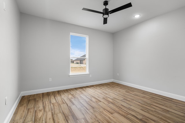 spare room with ceiling fan and light wood-type flooring