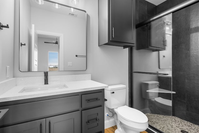 bathroom featuring an enclosed shower, vanity, toilet, and ceiling fan