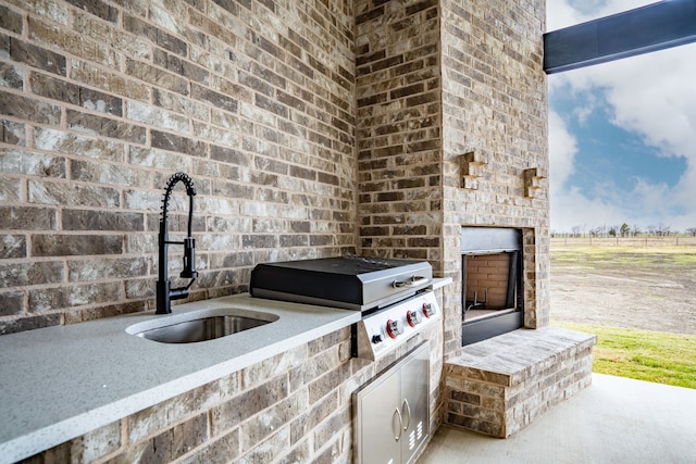 view of patio featuring area for grilling, sink, and exterior fireplace