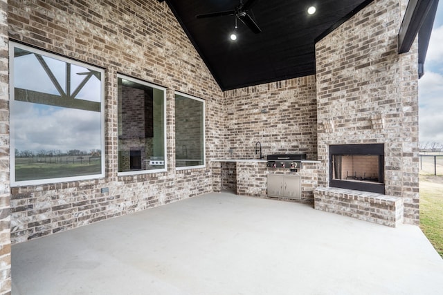 view of patio featuring area for grilling, a grill, ceiling fan, and an outdoor brick fireplace