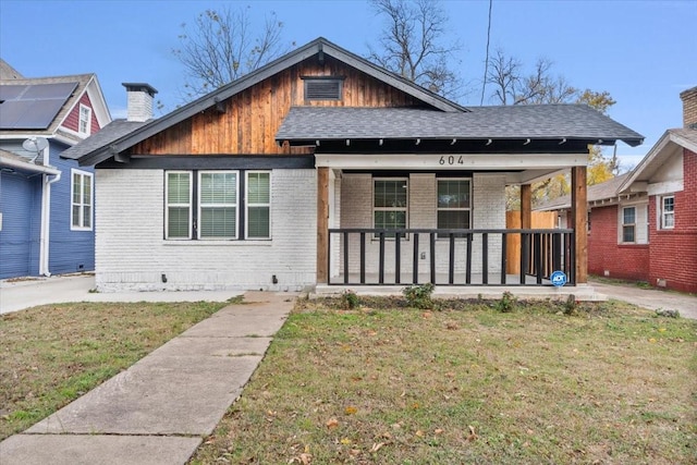 bungalow-style home with covered porch and a front yard