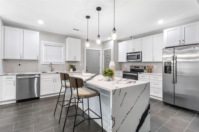 604 S Fitzhugh Ave, Dallas, TX 75223 - kitchen with tasteful backsplash, a sink, stainless steel appliances, a kitchen bar, and visible vents