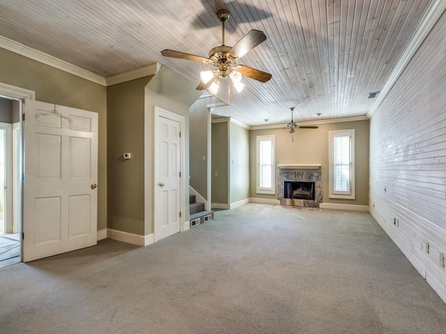 unfurnished living room with ceiling fan, light colored carpet, ornamental molding, and a fireplace