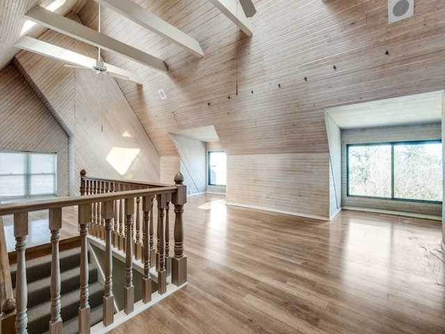 bonus room featuring ceiling fan, plenty of natural light, wooden ceiling, and wood walls