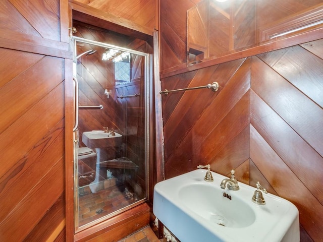 bathroom with a shower with shower door and sink