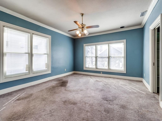 unfurnished room with crown molding, a healthy amount of sunlight, and carpet