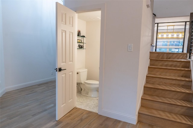 bathroom with hardwood / wood-style flooring and toilet