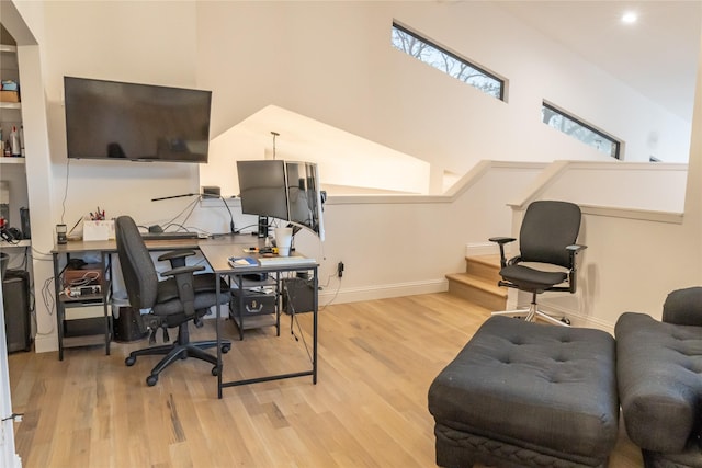 office space with a skylight and light wood-type flooring