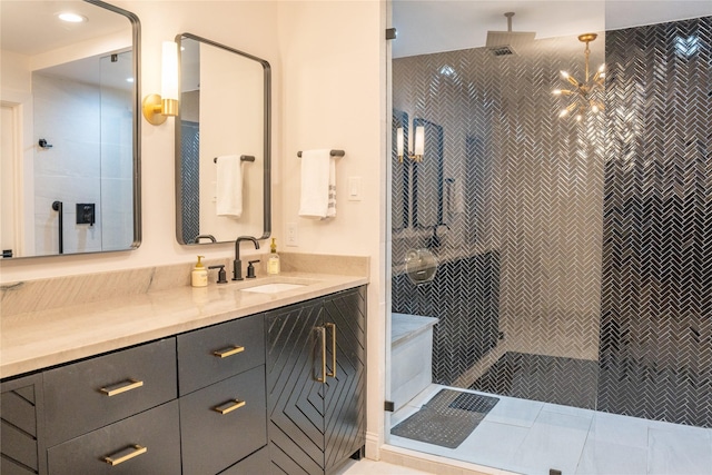 bathroom with tile patterned flooring, vanity, tiled shower, and an inviting chandelier