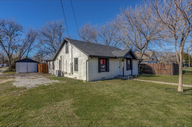 view of front of house featuring a shed, central AC unit, and a front lawn