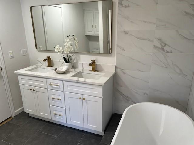 bathroom with vanity and a tub to relax in