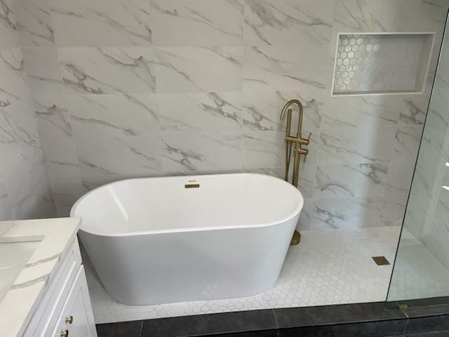 bathroom featuring a tub, tile patterned flooring, and vanity