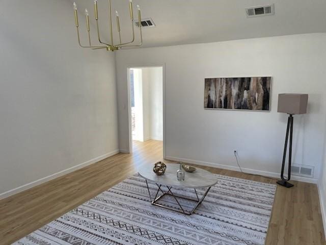 living room with hardwood / wood-style flooring and a notable chandelier