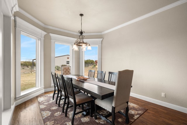 dining area with dark hardwood / wood-style flooring, a chandelier, and ornamental molding