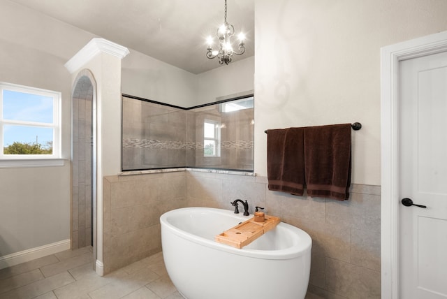 bathroom featuring tile patterned floors, a notable chandelier, shower with separate bathtub, and tile walls