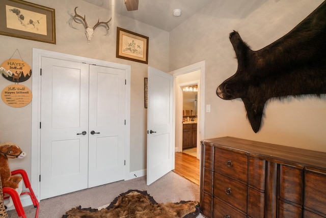 bedroom with ceiling fan, light carpet, and a closet