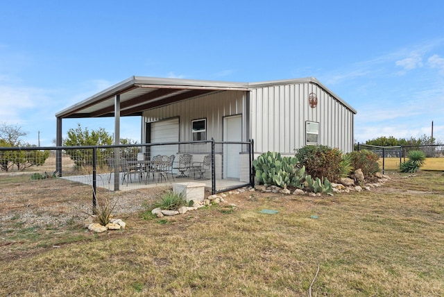 exterior space featuring a front yard, a garage, and a patio area