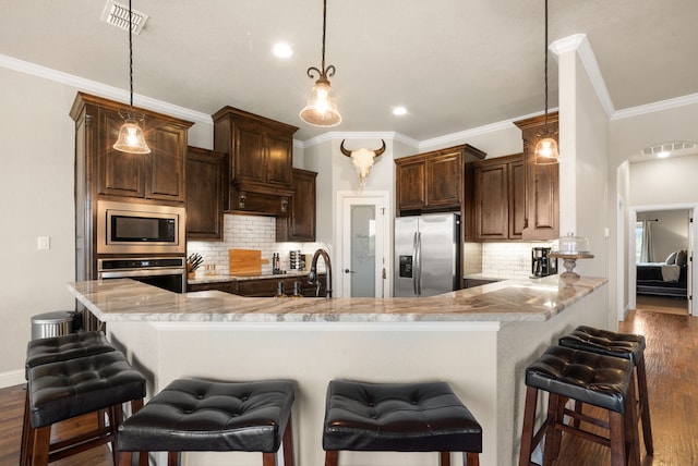 kitchen featuring a breakfast bar area, kitchen peninsula, decorative backsplash, and stainless steel appliances