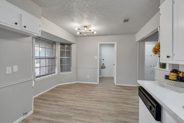 kitchen with white cabinetry, dishwasher, and a textured ceiling