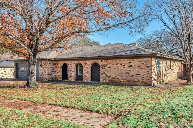 single story home featuring a garage and a front lawn