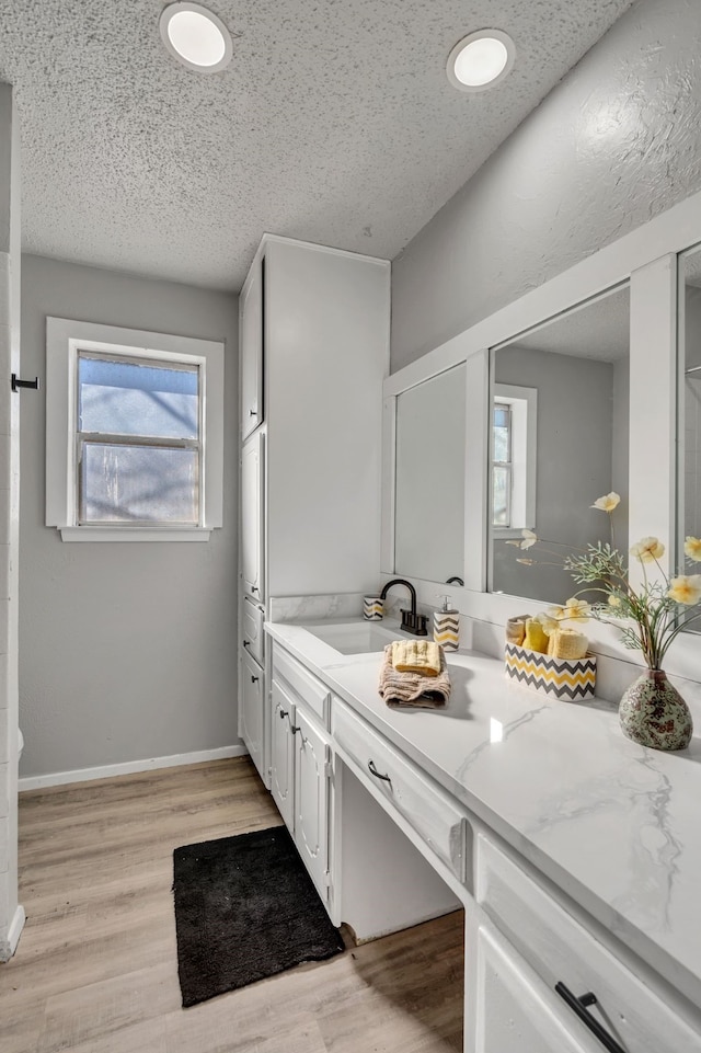 bathroom with vanity, hardwood / wood-style flooring, and a textured ceiling