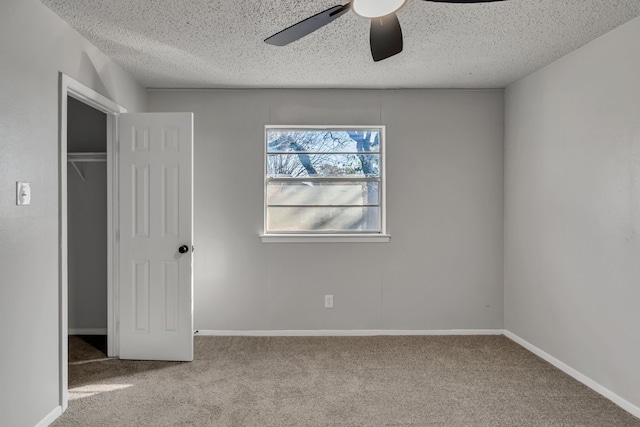 unfurnished bedroom with light carpet, ceiling fan, a closet, and a textured ceiling