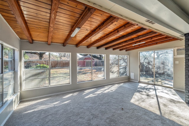 unfurnished sunroom featuring beamed ceiling, a healthy amount of sunlight, and wood ceiling