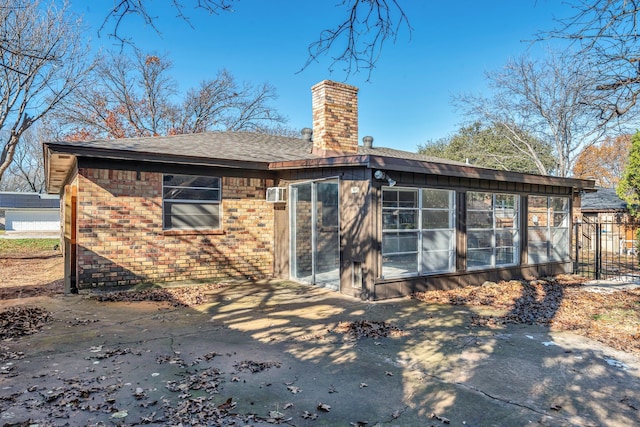 rear view of property with a sunroom and a patio area