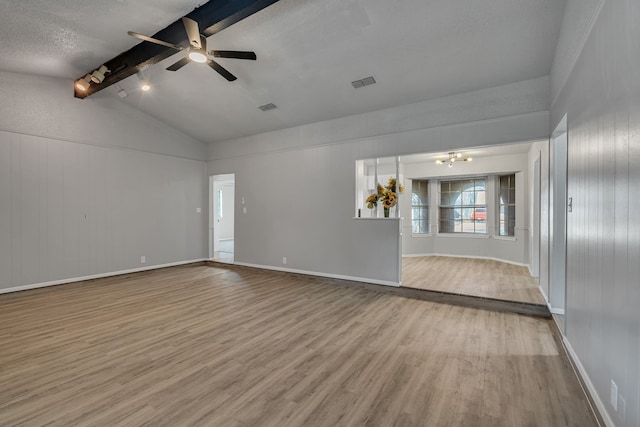 empty room featuring lofted ceiling with beams, ceiling fan, and light hardwood / wood-style floors