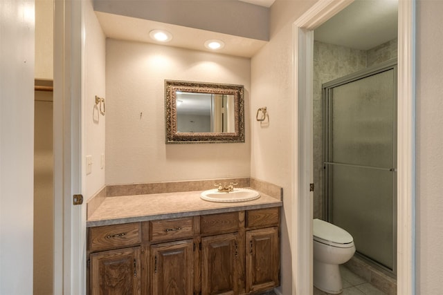 bathroom with vanity, a shower with shower door, tile patterned floors, and toilet